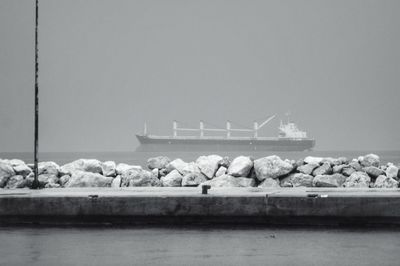 Boats in sea against clear sky