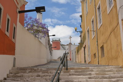 Staircase amidst buildings against sky