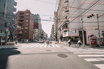 People riding bicycles on street in city