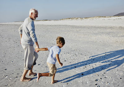 Grandfather and grandson strolling on the beach