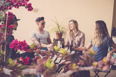 Friends with beer bottles talking in restaurant