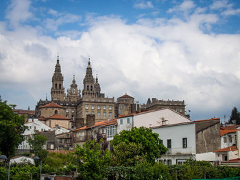 Buildings in city against cloudy sky