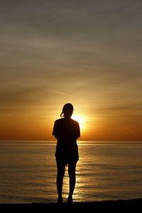 Woman silhouette, look at the beauty, sunrise from the sea alone