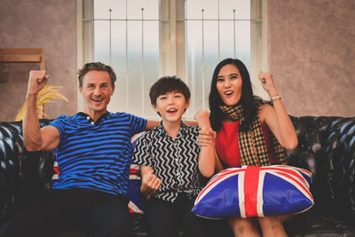 Portrait of happy family sitting on sofa at home