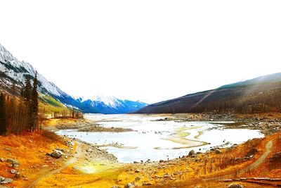 Scenic view of lake and mountains against clear sky