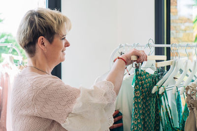 Mature woman choosing clothes at store