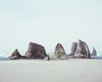 Rear view of person standing by rock formations at face rock state park