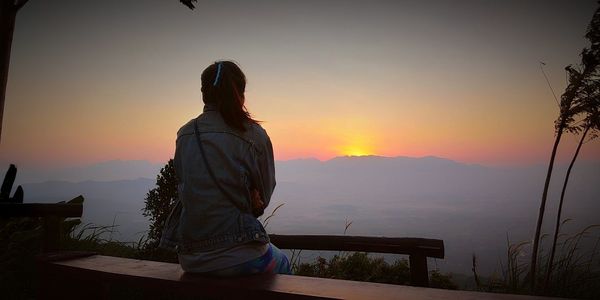 Rear view of silhouette man looking at sunset