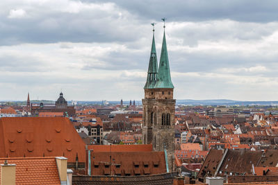 View of buildings in town against cloudy sky