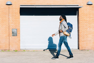 Full length of man walking by shutter