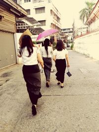 Rear view of women walking in city