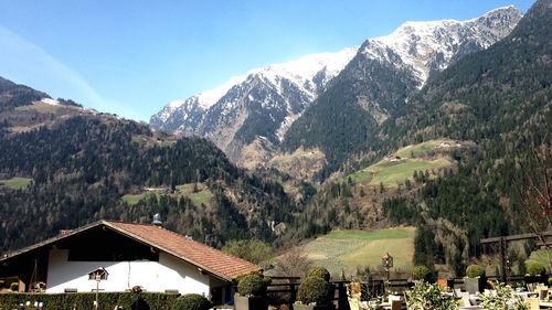 Scenic view of mountains and houses against sky