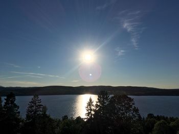 Scenic view of lake against bright sun