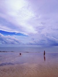 Boy crouching on beach