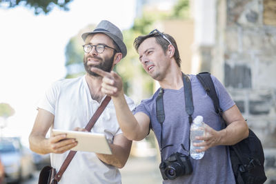 Two men with digital tablet outdoors