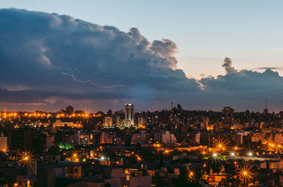 High angle view of illuminated buildings against sky at night