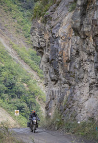 Man driving touring motorbike on dirt road, santa teresa, piura, peru
