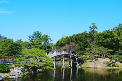 Gazebo by trees against clear sky