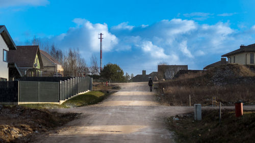 Street amidst buildings against blue sky