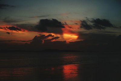 Scenic view of sea against dramatic sky during sunset