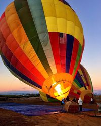 Colorful hot air balloons against sky on field