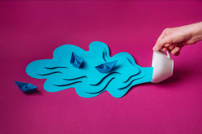 Close-up of human hand against pink wall