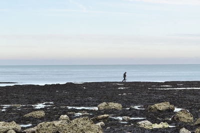 Man standing at beach against sky