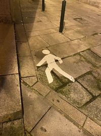 High angle view of arrow sign on footpath