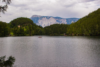 Scenic view of lake by trees against sky