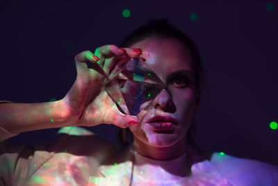 Close-up portrait of woman holding multi colored light painting