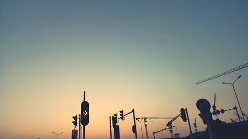 Silhouette of telephone pole against clear sky during sunset