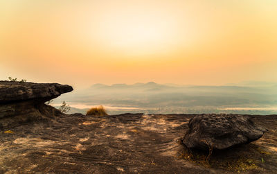 Rock formation on land against sky during sunset