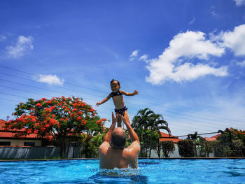 Father playing with his little daughter in the swimming pool