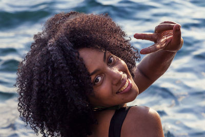 Portrait of smiling young woman against sea