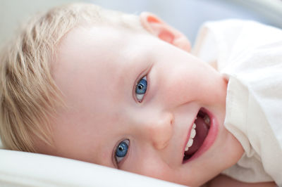 Portrait of smiling boy lying on bed