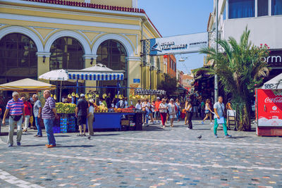 People walking on street against buildings in city