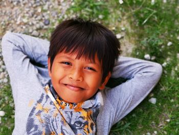 Portrait of smiling boy lying on grass