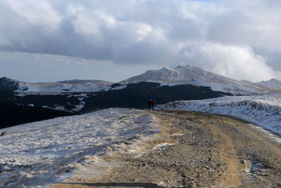 People walking on dirt road during winter