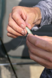 Midsection of man. hands with fish lure 