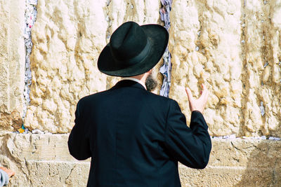 Rear view of man standing against wall