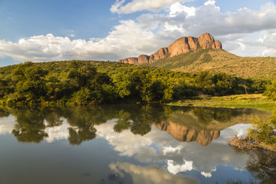 Reflection of trees and rock in lake