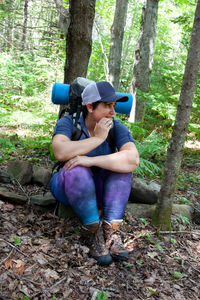 Full length of boy sitting in forest