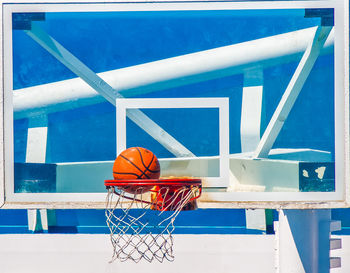 Low angle view of basketball hoop against blue sky