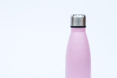 Close-up of pink bottle against white background