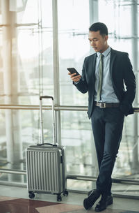 Full length of a young man using mobile phone