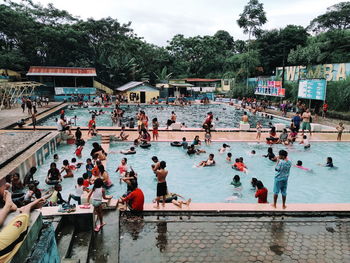 Group of people by swimming pool against trees