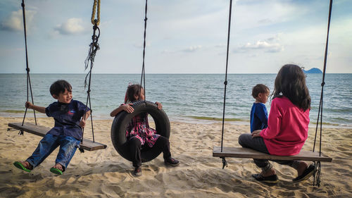 Children on swing at beach