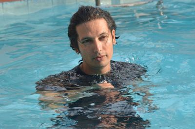 Man looking away while swimming in pool