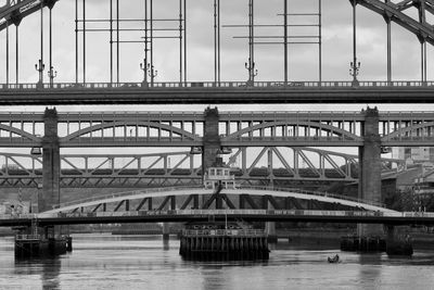 Bridge over river against sky in city