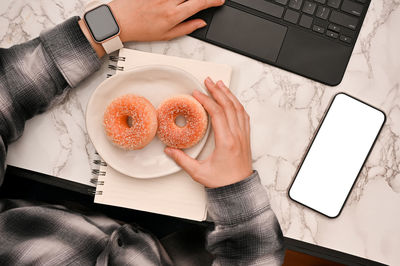 Cropped hands of woman using digital tablet on table